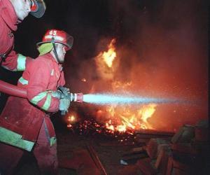 Fireman or firefighter in action with the fire hose extinguishing a fire puzzle