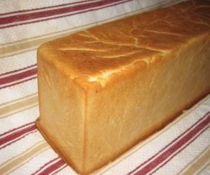 A loaf of bread made in a bread pan to be cut into slices, like a sliced bread puzzle