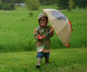 Boy with his umbrella and rain jacket under the spring rain puzzle