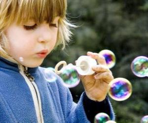 Child playing to blow soap bubbles puzzle