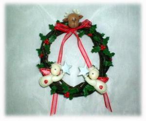 Christmas wreath decorated with holly leaves a head of a reindeer, two angels and a red bow puzzle