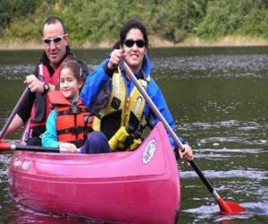 Family, father, mother and daughter, sailing and paddling a canoe, equipped with life vests puzzle