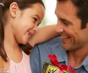 Father with his daughter while she is giving the gift puzzle