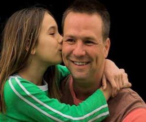 Girl congratulating his father with a hug and a big kiss puzzle