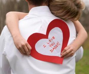 Girl congratulating his father with a hug and a paper heart puzzle