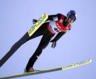 Skier in mid-flight by jumping from a trampoline