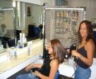 Hairdresser combing and drying the hair to a client in the beauty salon or the hairdressing salon