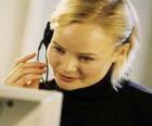 Telemarketer working in the computer with headphones and microphone