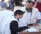 Boy studying with his teacher, both with Kippah, ritual small skullcap