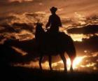 Cowboy riding at dusk