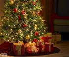 Christmas tree decorated with beads, ribbons, a big star and with gifts underneath