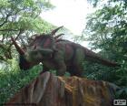 Triceratops dinosaur in the forest on the top of a large rock
