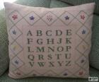 Cushion with the alphabet letters, made at Cross-stitch