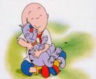 Caillou sitting on the floor and hugging his cat Gilbert