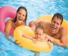 Young couple with their daughter in the pool