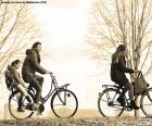 Happy family bicycle strolling through the Park in winter