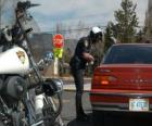 Motorized police officer with his motorcycle and put a fine on a driver