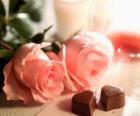 Two pink roses with two chocolates in heart-shaped