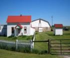 Small farm or farm house with the water well and its fenced enclosure