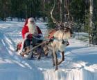 Santa Claus in his sleigh with a reindeer on snow