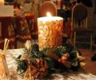 Candle ignited as a centerpiece adorned with sprigs of holly and fir