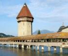 The wooden and covered bridge Kapellbrücke (the Chapel Bridge) and the tower Wasserturm in Lucerne, Switzerland