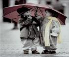 Children walking in the rain with her umbrella