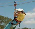 Adventurous girl jumping with a rope and harness