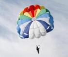 Parachutist down through the clouds in a parachute after jumping from an airplane