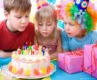 Girl in the moment of blowing out the candles on her birthday cake