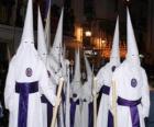 Nazarenes or penitents in a procession during Holy Week with hood or cone, robe and cape