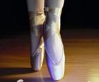 The feet of a dancer with the ballet shoes