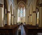 Inside view of a Catholic Church, with the banks for the parishioners and altar in the background