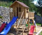 Wooden structure of a playground, where children can play with a small house and playground slide