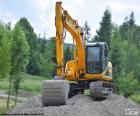 Yellow excavator atop a mound of Earth