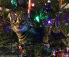 A curious cat among the decorations hung from the Christmas tree