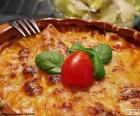 An exquisite baked lasagna decorated with a tomato and some leaves