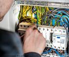 Electrician working in distribution board. The electrician is a professional who performs installations and repairs related to electricity