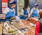 Three fisherwomen working in the fish shop of the supermarket