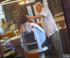 Barber shaving a customer with foam and blade