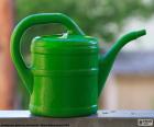 A green plastic watering can, is used for watering plants