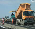 Several vehicles and operators working in a road asphalt