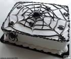 A delightful and terrifying cake for halloween, with a spider web decoration and various spiders