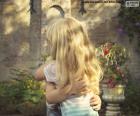 Image of two young girls getting a big hug from friends