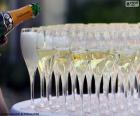 A waiter filling cups of Champagne at a celebration