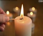 Person lighting a white candle