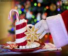 Santa Claus leaves a Christmas Cookie with a cup full of sweets