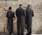 Three Jews praying at the Wailing Wall in Jerusalem, the holiest place in Judaism