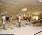 A large and ornate wedding hall, prepared for the arrival of guests and grooms