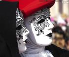 Two classic white Venetian masks decorated with black and glitter details